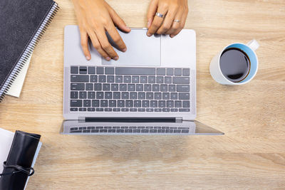 Low section of person using smart phone on table