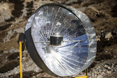 Water boiling in metal kettle placed on solar cooker on rocky ground in himalayas mountains in nepal on sunny day