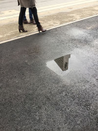 Low section of man walking on road