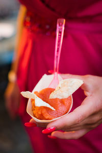 Midsection of woman holding snack in paper plate