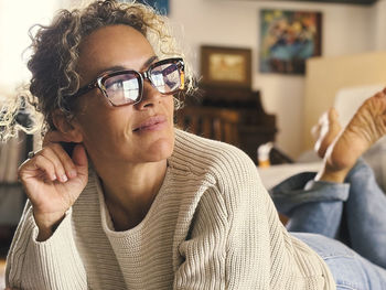 Portrait of young woman wearing sunglasses while sitting at home