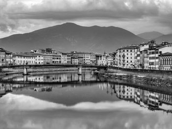 Reflection of old buildings and mountain on the river