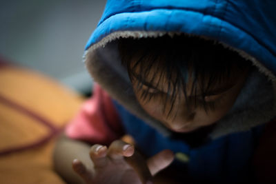 Close-up of boy in blue hooded shirt at home