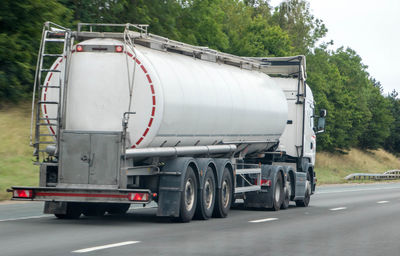 Vehicles on road against trees