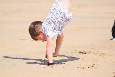 Full length of young woman playing on beach