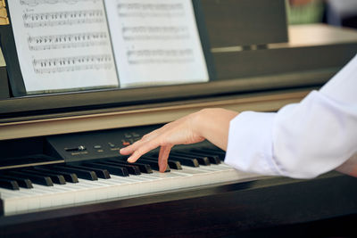 Midsection of man playing piano