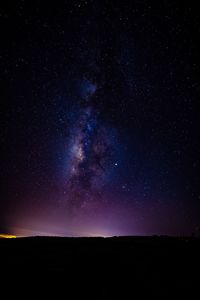 Low angle view of silhouette landscape against star field at night