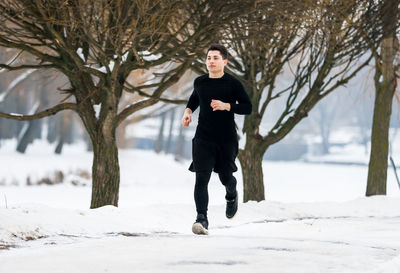 Full length of man standing on snow covered field