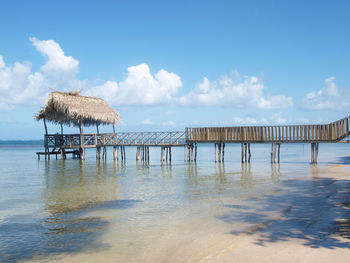 Wooden posts on pier over sea against sky