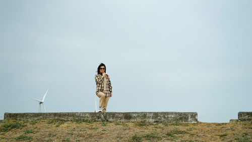 Woman standing on field against clear sky