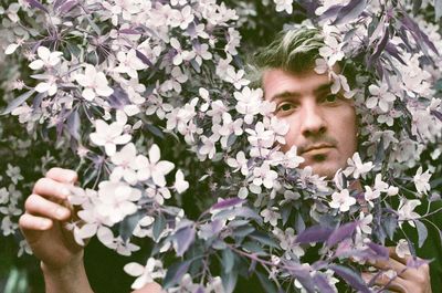 Low angle view of young man holding apple  flowers