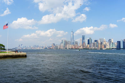 Scenic view of sea by city against sky