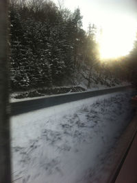 Snow covered road against sky during winter