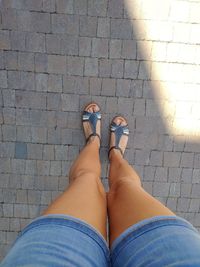 Low section of woman standing on footpath