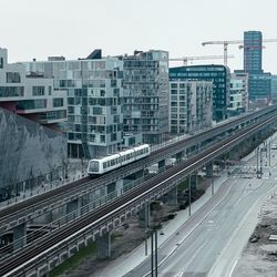 Railroad tracks in city against sky