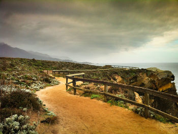 Scenic view of landscape by sea against sky