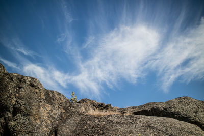 Low angle view of rocks against blue sky