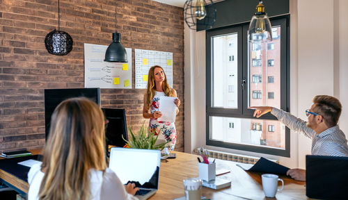 Businesswoman explaining to colleagues in meeting at office