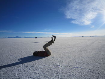 Optical illusion of woman lifting man at salar de uyuni