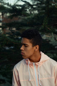 Portrait of young man looking away in forest