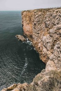 Rock formations by sea against sky