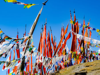 Low angle view of bunting flags against clear blue sky