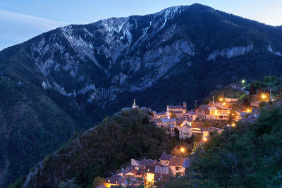 High angle view of illuminated houses in town against sky at night