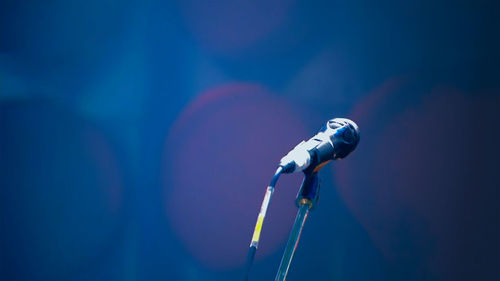 Close-up of microphone against blue wall
