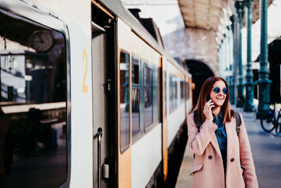 Woman standing by train at railroad station