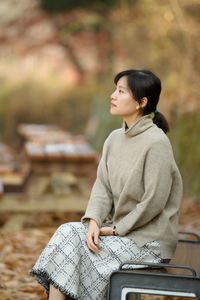A lady sitting on the autumn bench