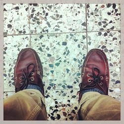 Low section of woman standing on tiled floor