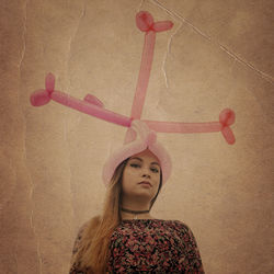 Portrait of young woman standing against wall