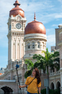 Woman standing by historic building