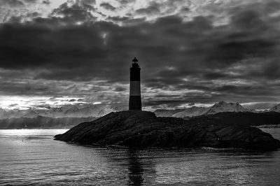 Lighthouse by sea against sky