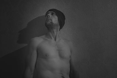 Portrait of young man standing against wall