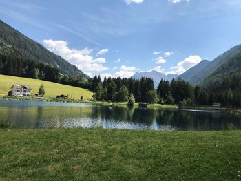 Scenic view of lake by trees against sky