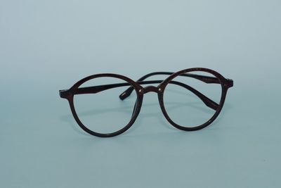 Close-up of eyeglasses on table against blue background