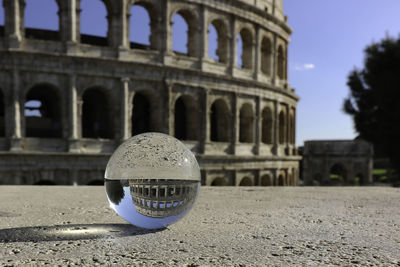 Close-up of crystal ball against colosseum