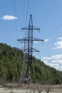 A high-voltage tower in front of the mountain. sunny good day. front view.