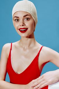 Portrait of young woman in bikini against clear blue sky