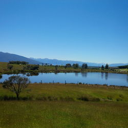 Scenic view of lake against clear blue sky