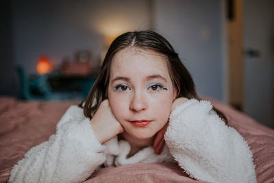 Portrait of tween girl laying on her bed looking at camera