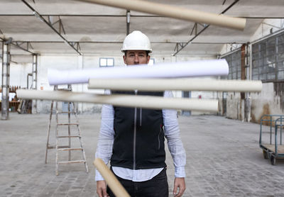 Male architect throwing cardboards while standing in building