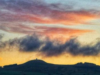 Scenic view of dramatic sky over silhouette landscape