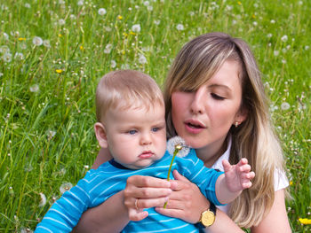 Mother with cute baby boy on field