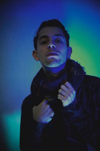 Portrait of young man against blue background