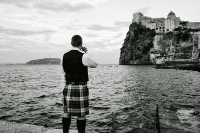 Rear view of man standing in sea