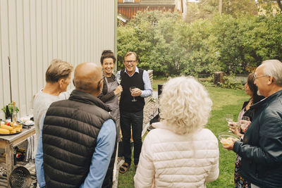 Happy male and female active seniors enjoying during garden party