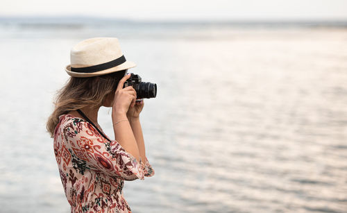 Midsection of woman photographing sea