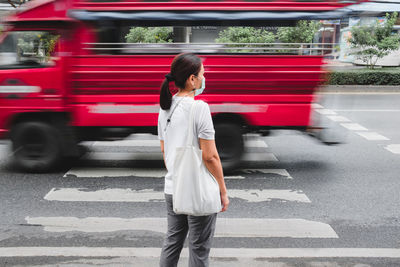 Full length of woman standing on road in city